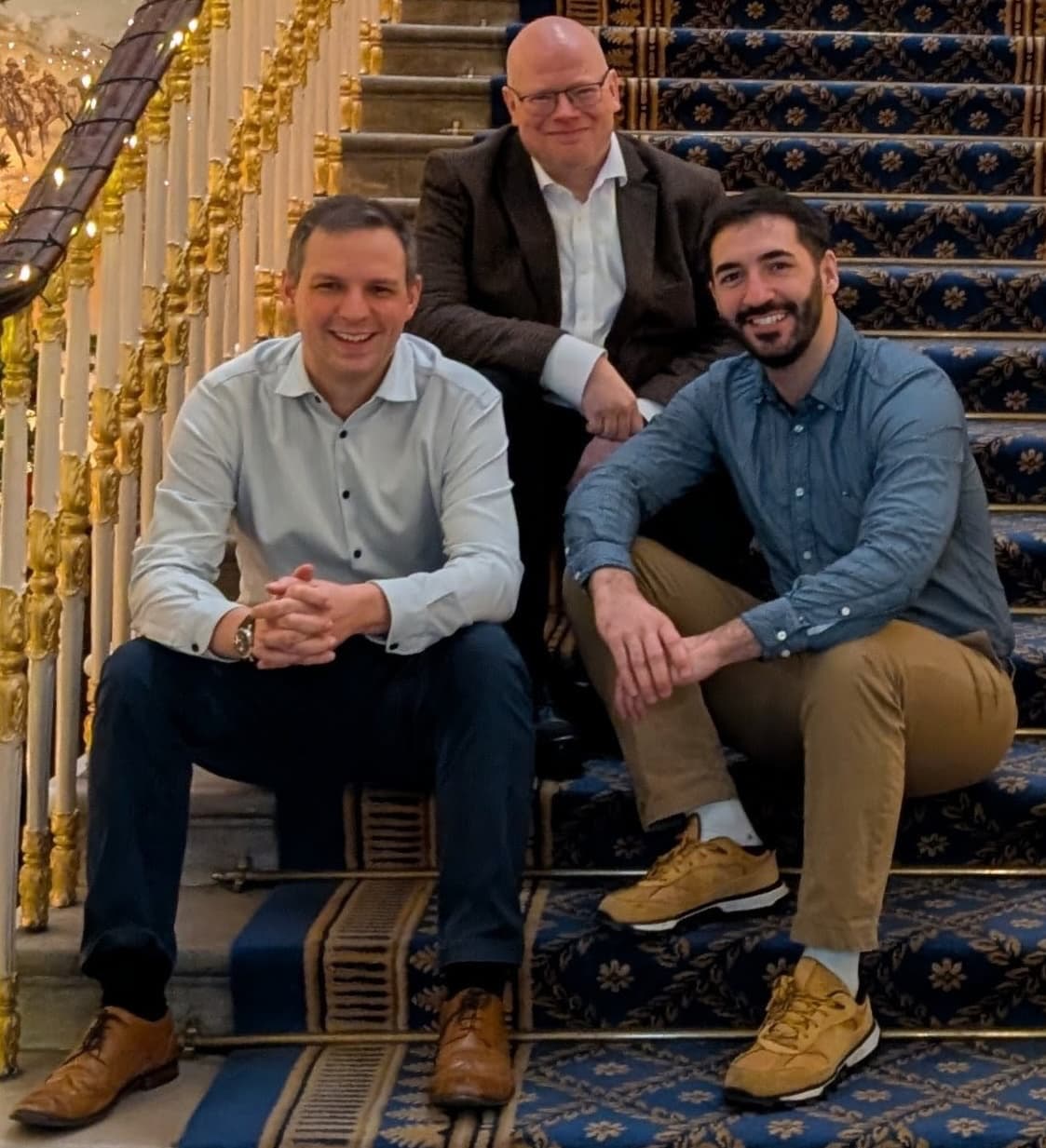 The three founders of Unbound sitting on stairs